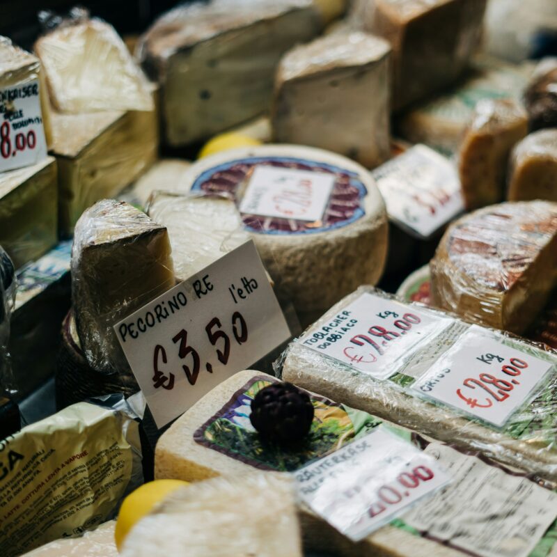 Une vitrine d'un magasin de vente de fromage, présentant de nombreux blocs de fromage variés disposés de manière appétissante.