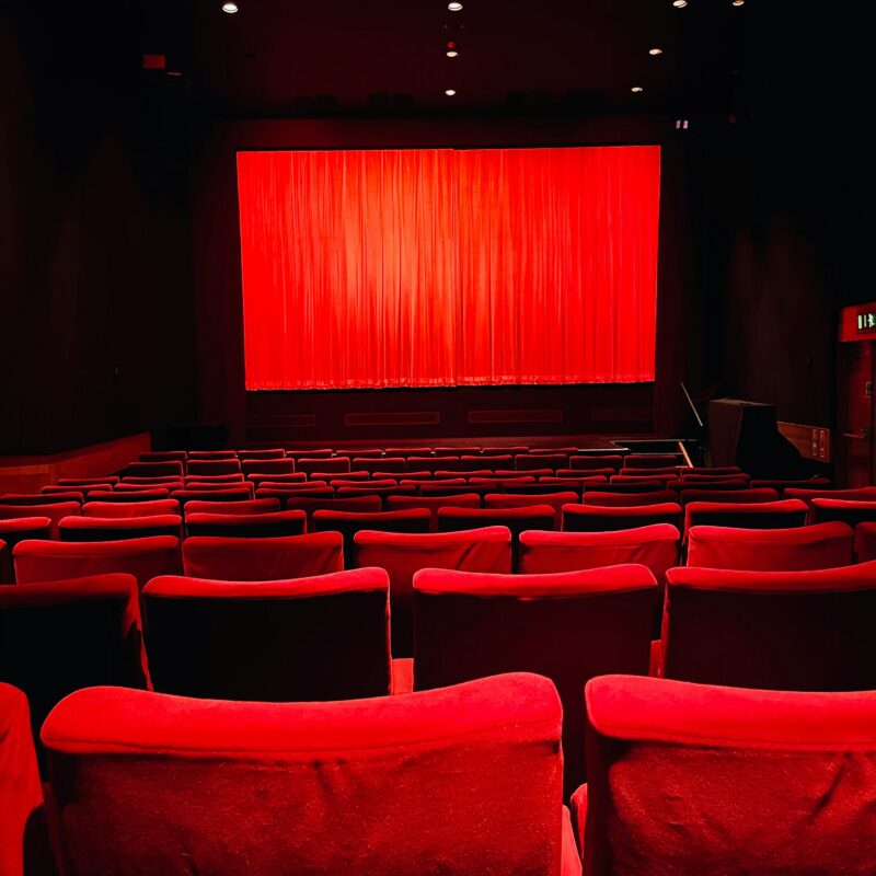 Salle de cinéma aux sièges rouges.