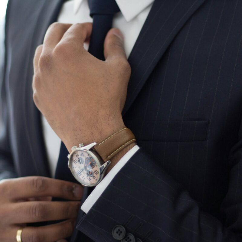 Un homme en costume portant une montre au poignet de la marque reservoir watch