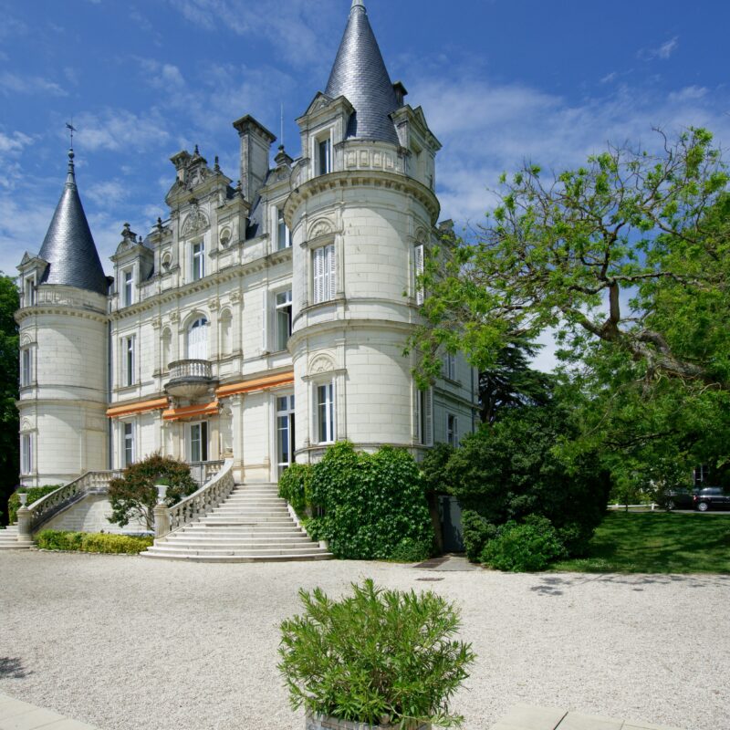 Un grand château blanc dans un environnement naturel