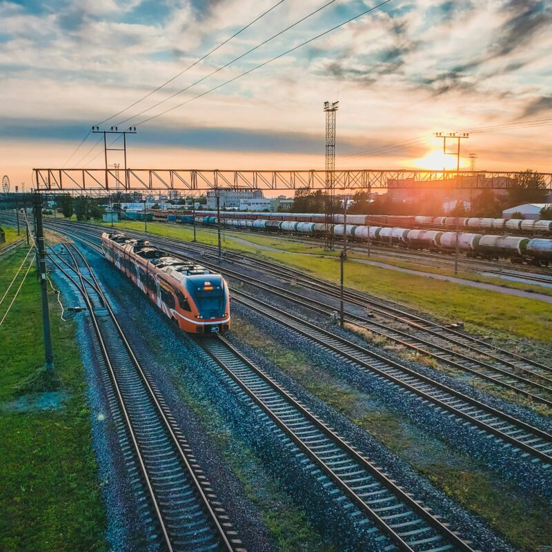 Un train descendant les voies ferrées à côté d'un champ verdoyant