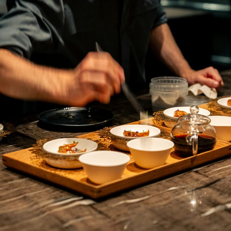 Personne se servant dans des plats avec des baguettes